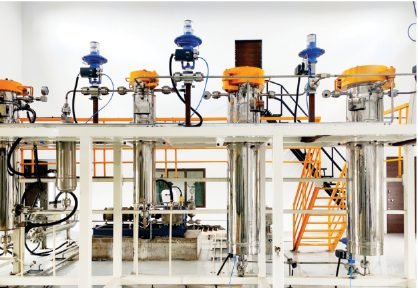 Pilot-scale extraction skid with a separator train, blue actuated valves and access stairs.
