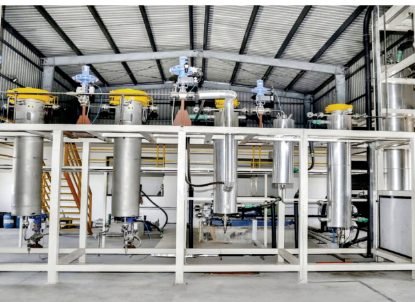 Full production extraction plant with multiple vessels installed under a steel shed structure.